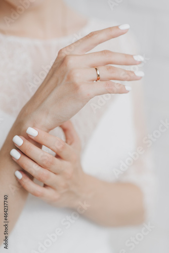 hands of the bride in a white wedding dress close up