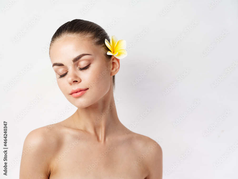 pretty woman with bare shoulders closed eyes charm flower in hair pretty woman with bare shoulders closed eyes charm flower in hair
