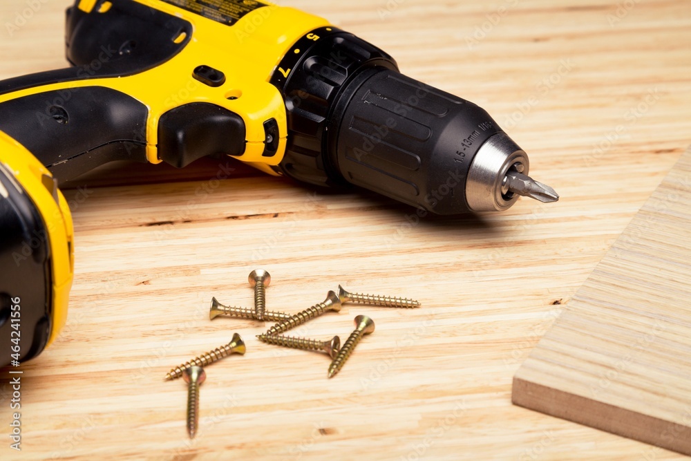drill gun with screws on wooden desk