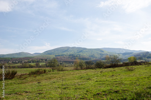 beautiful panorama of early autumn. rural fields against the backdrop of mountains. green field and blue mountains