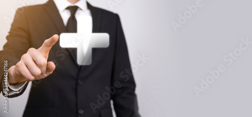 Businessman hold 3D plus icon, man hold in hand offer positive thing such as profit, benefits, development, CSR represented by plus sign.The hand shows the plus sign