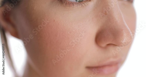 Close-up of young caucasian woman face making blush or powder on the face using two color makeup brush. Beauty, health and cosmetics. Skin care concept.