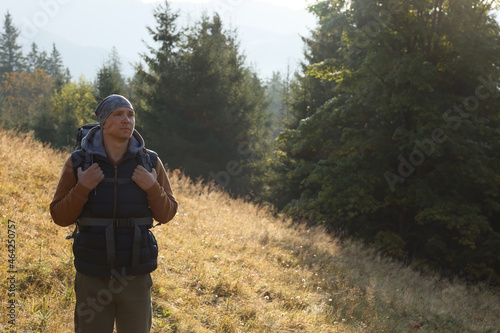 Tourist with backpack in nature on sunny day. Space for text