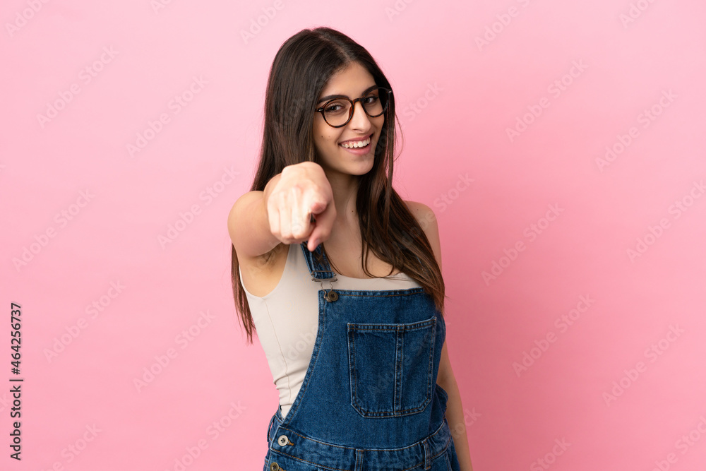 Young caucasian woman isolated on pink background pointing front with happy expression Young caucasian woman isolated on pink background pointing front with happy expression