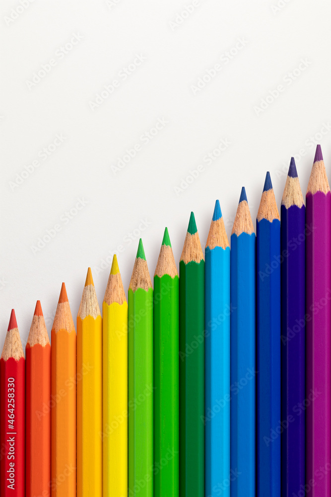 Colour pencils arranged diagonally on a white vertical paper background. Colour pencils arranged diagonally on a white vertical paper background.