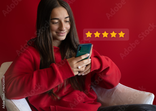 Girl Christmas shopping on smartphone submitting 5 gold star satisfaction feedback