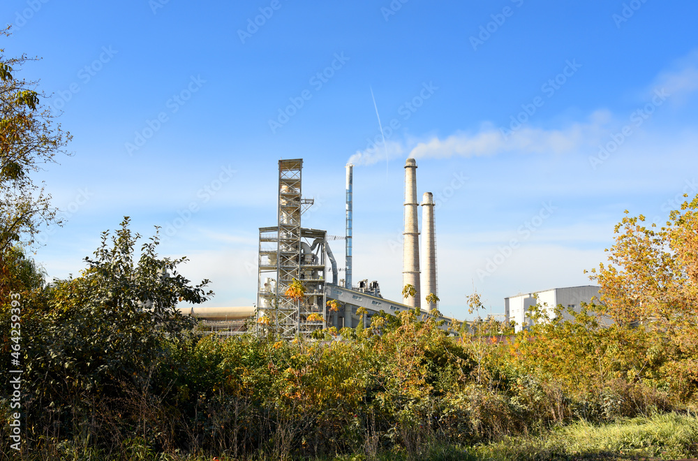 Obraz premium Refinery plant with pipes. Smoke tower of industrial factory CHP. Chimney smokestack emission. Plant with smoke frow pipe and environmental pollution. Ecology concept and poor environment.