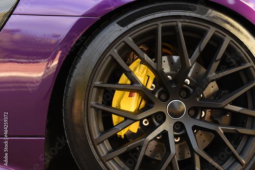 Alloy wheel with calipers and racing brakes of the sport car. Racing brake disc and low profile tyres. Race car test driving. Lower-profile tires of drag and drift cars. High-performance sports cars. © MaxSafaniuk