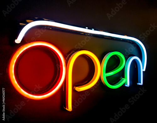 Bright electric neon red sign saying the word Open, indicating a store, shop, pub or restaurant is now open for business sign.