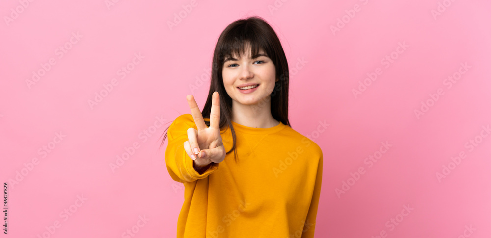 Young Ukrainian woman isolated on pink background smiling and showing victory sign Young Ukrainian woman isolated on pink background smiling and showing victory sign