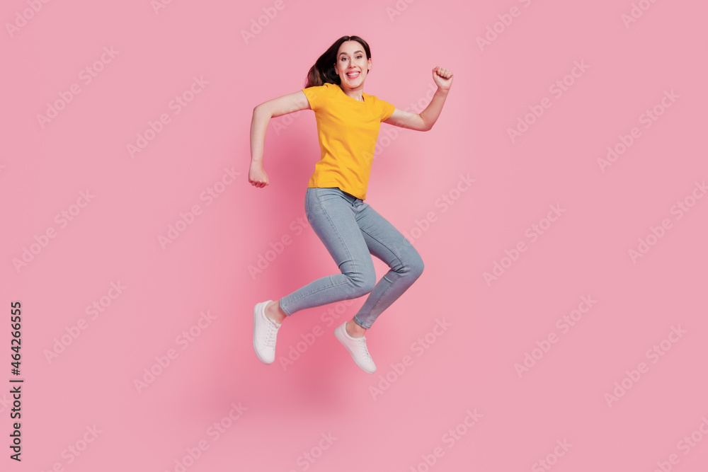 Photo of cheerful relaxed brunette woman jump run go shopping wear casual jeans clothes on pink background
