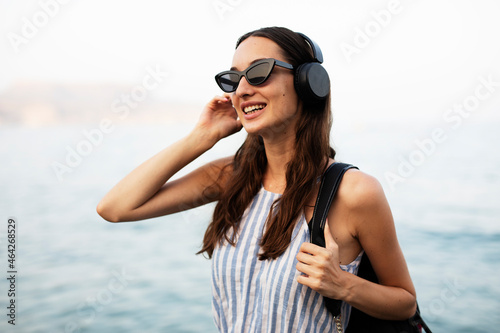 Hot woman relaxing on the sandy beach. Beautiful woman with headphones listening the music.