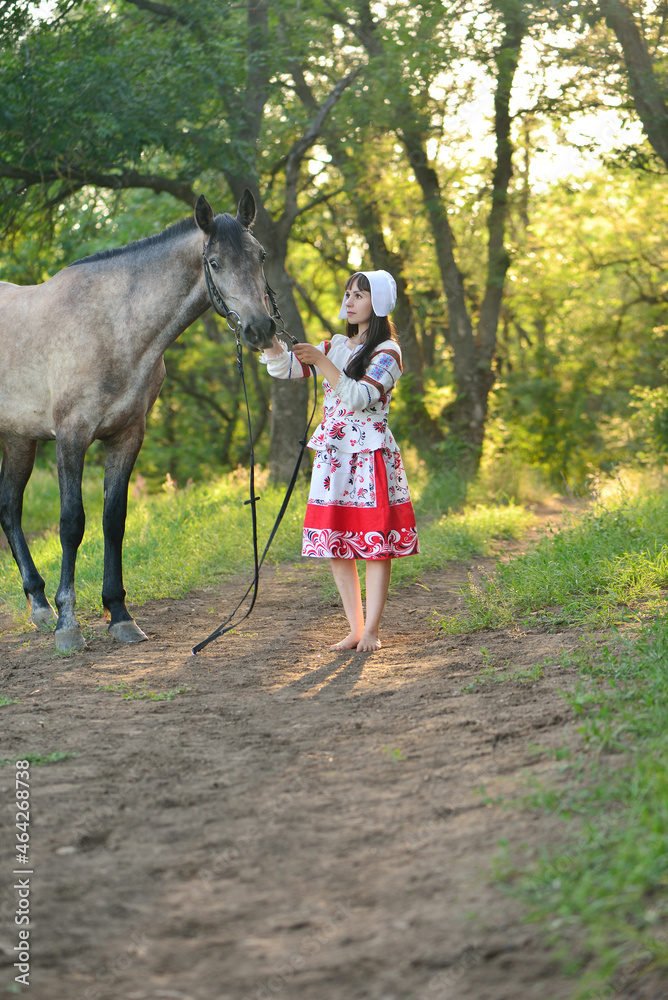 Girl in an old Russian outfit stroking a horse Girl in an old Russian outfit stroking a horse