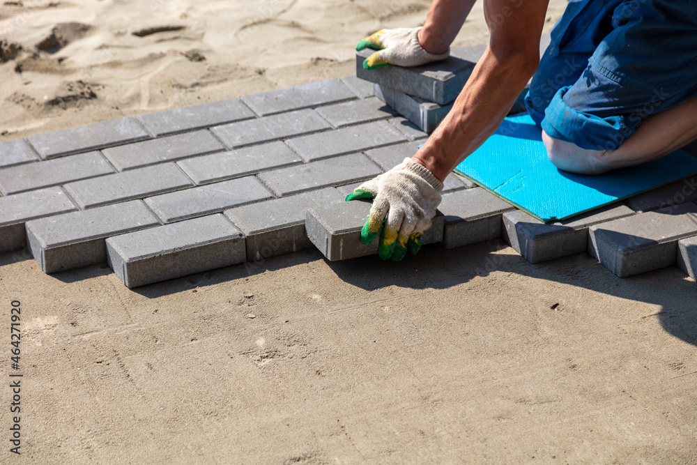 A worker lays paving slabs A worker lays paving slabs