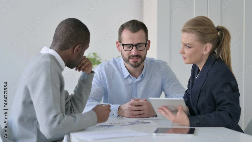 Male and Female Businessperson using Tablet While Preparing Reports Male and Female Businessperson using Tablet While Preparing Reports