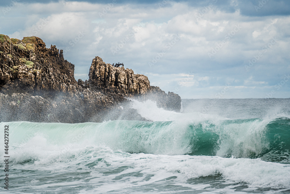 Ocean water splash on rock beach with beautiful sky and clouds. Sea wave splashing on stone at sea shore on winter. rocky coastline with white water swirling around the rocks Ocean water splash on rock beach with beautiful sky and clouds. Sea wave splashing on stone at sea shore on winter. rocky coastline with white water swirling around the rocks