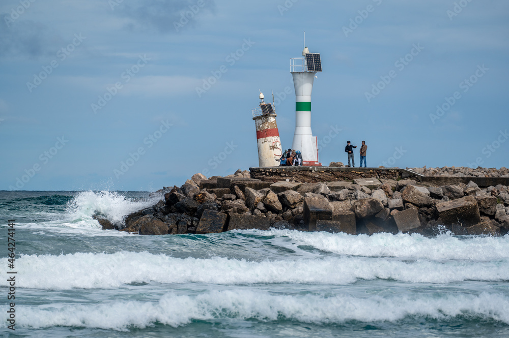 ISTANBUL, TURKEY - OCTOBER 12 ,2021: View of lighthouse at seashore against cloudy sky. Beautiful Lighthouse On The Rocks near Sile, Istanbul, Turkey, Black Sea. panorama