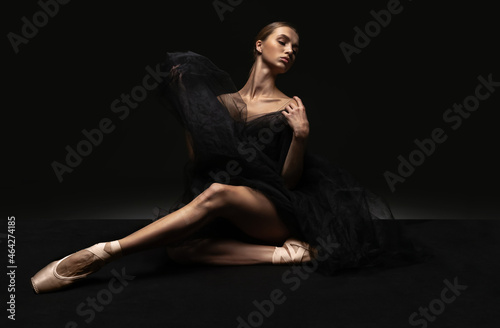 Portrait of young beautiful girl, modern ballet dancers posing isolated on dark background. Feelings, emotions concept © master1305