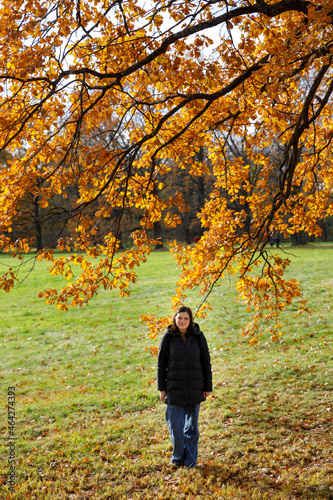 a woman in a down jacket in an autumn park