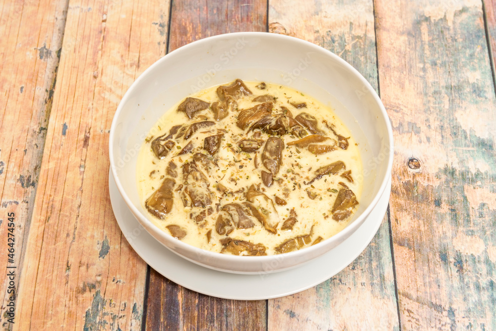 Boletus edulis stew with cream cheese in white bowl on wooden table Boletus edulis stew with cream cheese in white bowl on wooden table