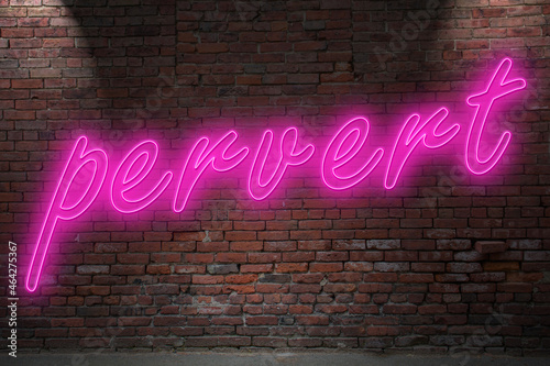 Neon pervert lettering on Brick Wall at night