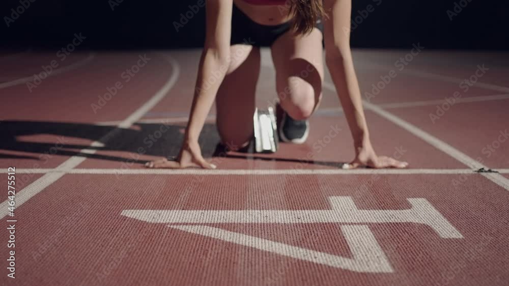 slow motion female runner at the start close-up in the dark at the stadium professional runner athletic