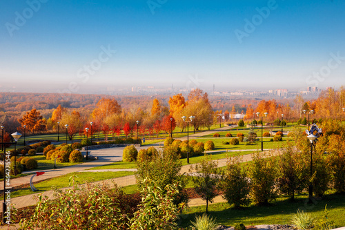 Top down photo in autumn showing the beautiful fall autumn colours of a park near Planetarium and city in fog on background in Novosibirsk