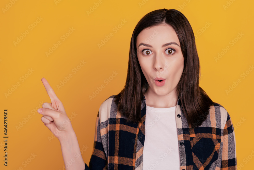 Photo of shocked crazy positive lady indicate finger empty space isolated yellow color background Photo of shocked crazy positive lady indicate finger empty space isolated yellow color background