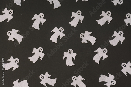 Pattern made of smiling ghost figures on a black backgorund. Halloween concept.