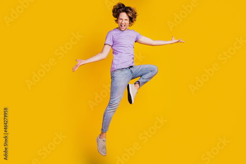 Photo of triumphant crazy man jump dance enjoy fun flight wear casual jeans clothes on yellow background