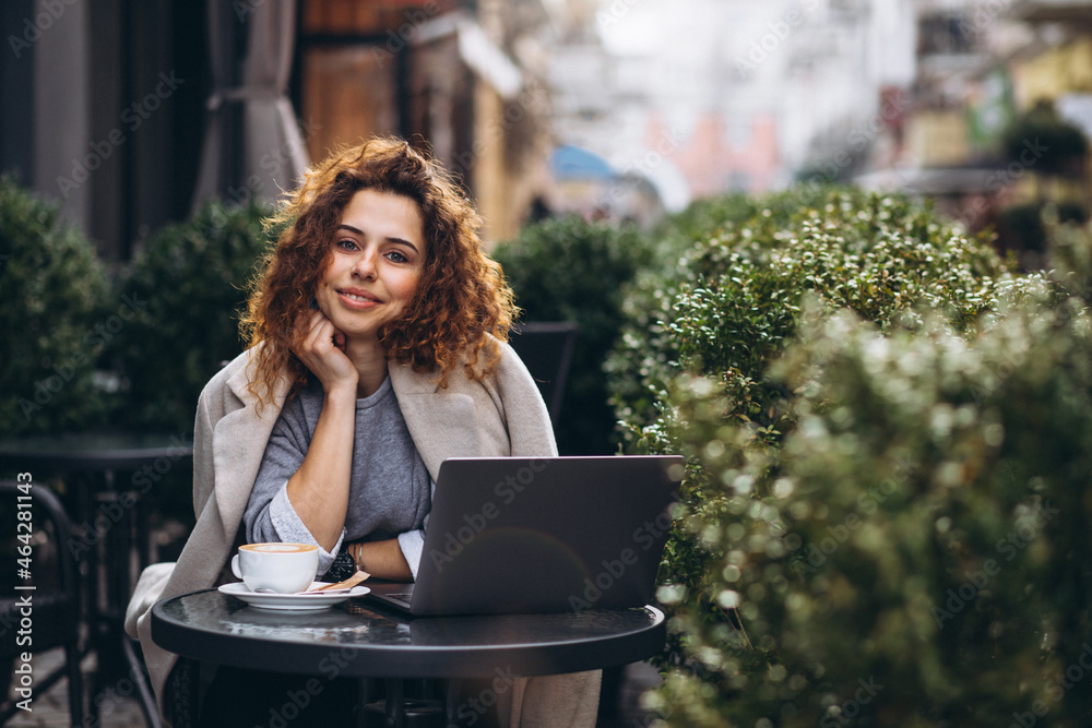 Young business woman working on a computer outside the cafe