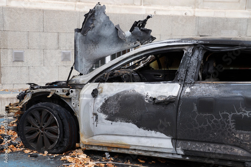 burned black car with open deformed hood