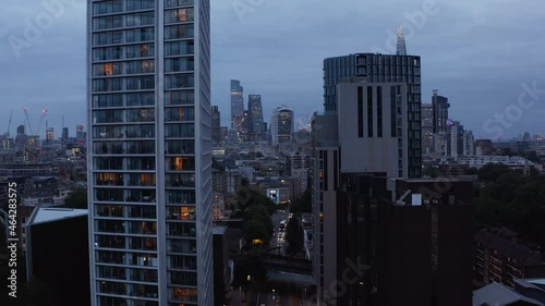 Ascending footage of Two Fifty One high rise apartment building. Evening panoramic view of cityscape and City skyscrapers in distance. London, UK photo