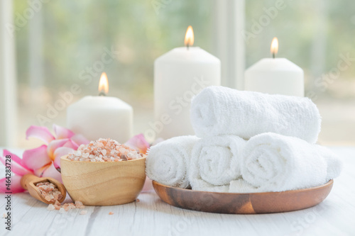 Natural relaxing spa composition on massage table in wellness center    with towels  flowers and salt  candle  on massage table in spa salon.