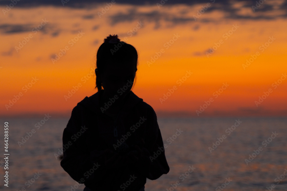 girl on the background of the sunset on the sea