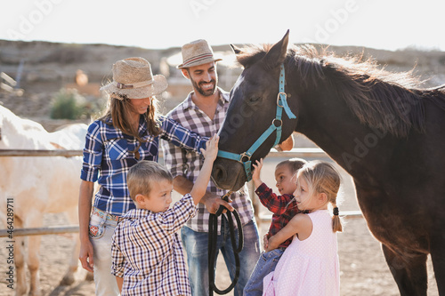 Family enjoy day at horse ranch - Farmer parents with children outdoor - Animal love and care photo