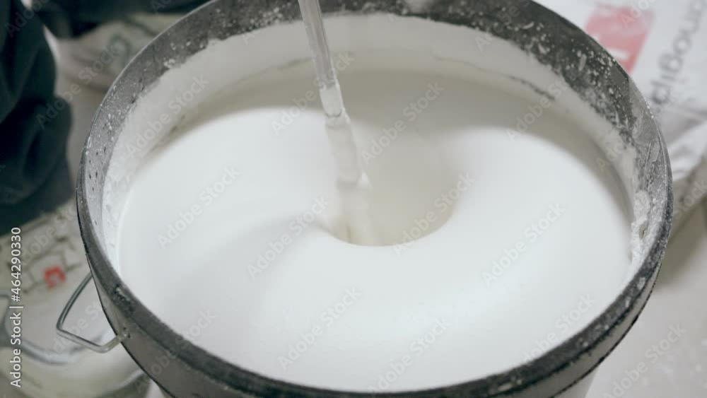 White putty for walls is mixed in a bucket White putty for walls is mixed in a bucket