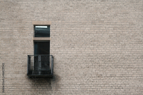prosta ceglana ściana z czarnym balkonem