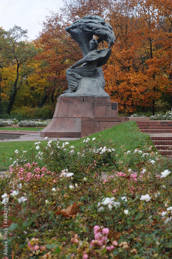Frederic Chopin statue monument in Lazienki (Royal Baths) Park in Warsaw, Poland in autumn with foilage on the trees