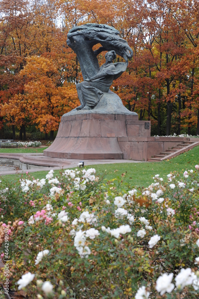 Frederic Chopin statue monument in Lazienki (Royal Baths) Park in Warsaw, Poland in autumn with foilage on the trees