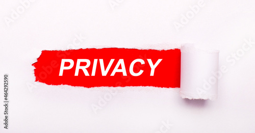 On a bright red background, white paper with a torn stripe and the inscription PRIVACY