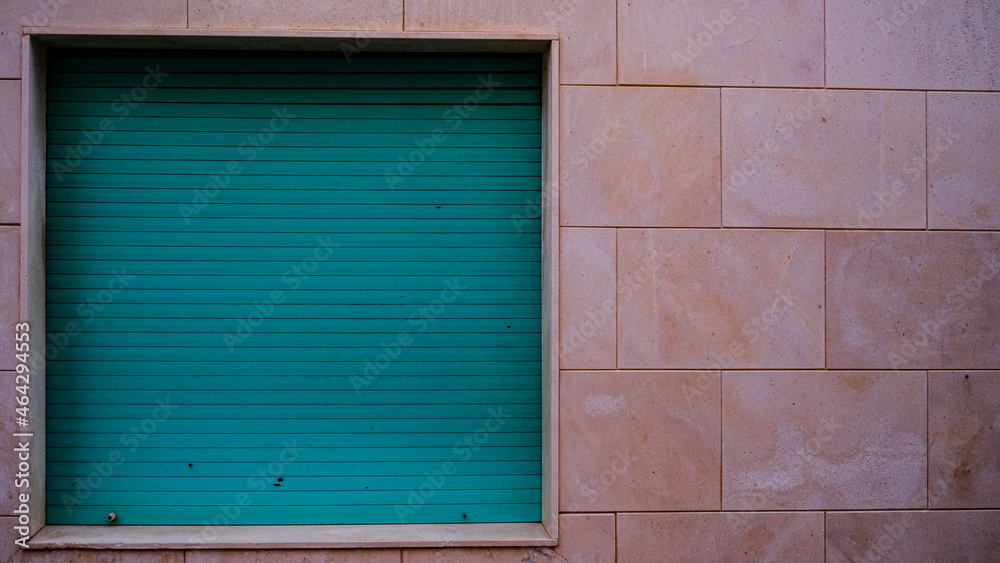 window with green shutter on pink wall. copy space