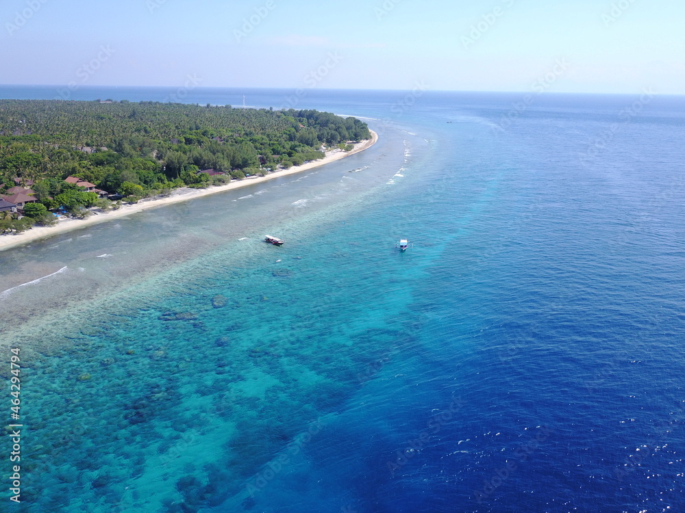 Drone landscape island paradise summer touring Indonesia islands Gili beach boats sailing ship sailing sea sea tropical vegetation sea waves plain sky clouds destination exotic