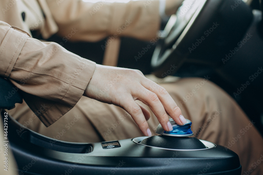 Woman sitting in car and puts her hand on transmission
