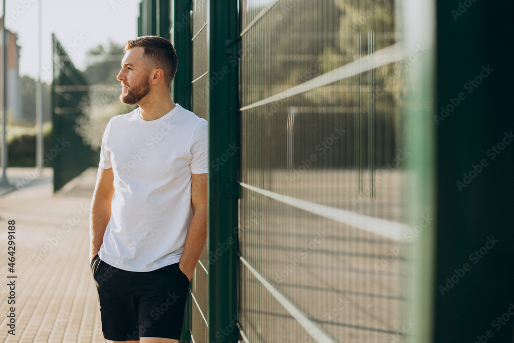 Fototapeta premium Young man standing at stadium in the morning