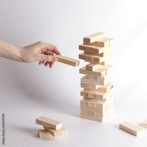 Close-up of fingers prevents the jenga wood block from falling