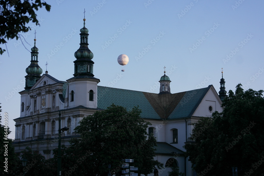  look up! Сatholic сathedral in Krakow,  symbolic white hot air balloon in the sky.  City summer landscape like postcard. Kościół Bernardynów on the Bernardyńska street.