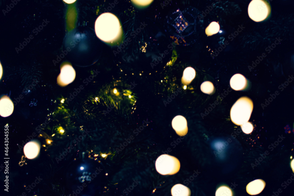 Blurred defocused New Year or Christmas tree branches with beautiful bokeh from electric LED lights Blurred defocused New Year or Christmas tree branches with beautiful bokeh from electric LED lights