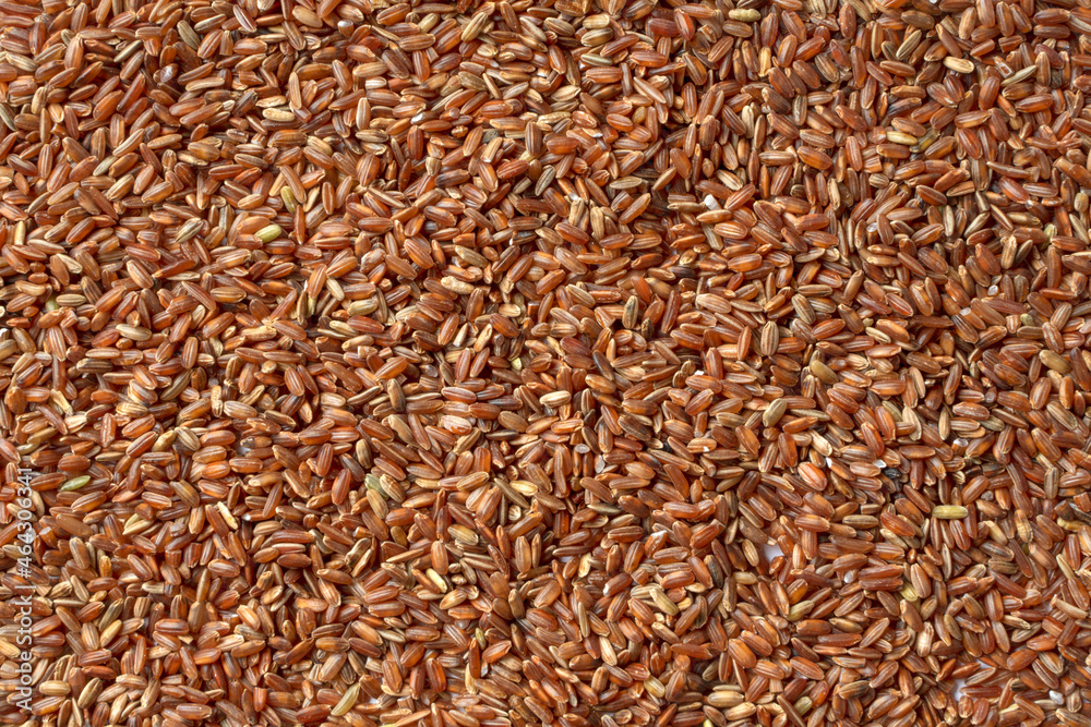 Brown rice close-up texture. Whole grain, a source of fiber and vitamins. Unpolished red rice background. A high-quality photo of cereals