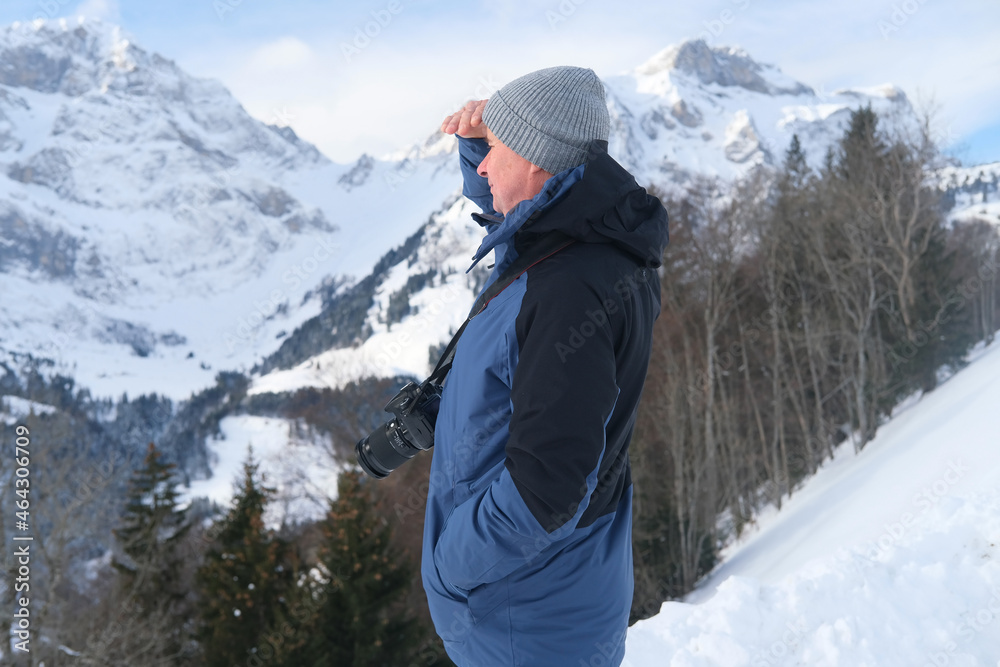 elderly man with camera, mountain hiker admiring mountain winter landscape, Sports Concept, Healthy Lifestyle, Winter Activity, beautiful winter natural landscape, walks in winter white forest